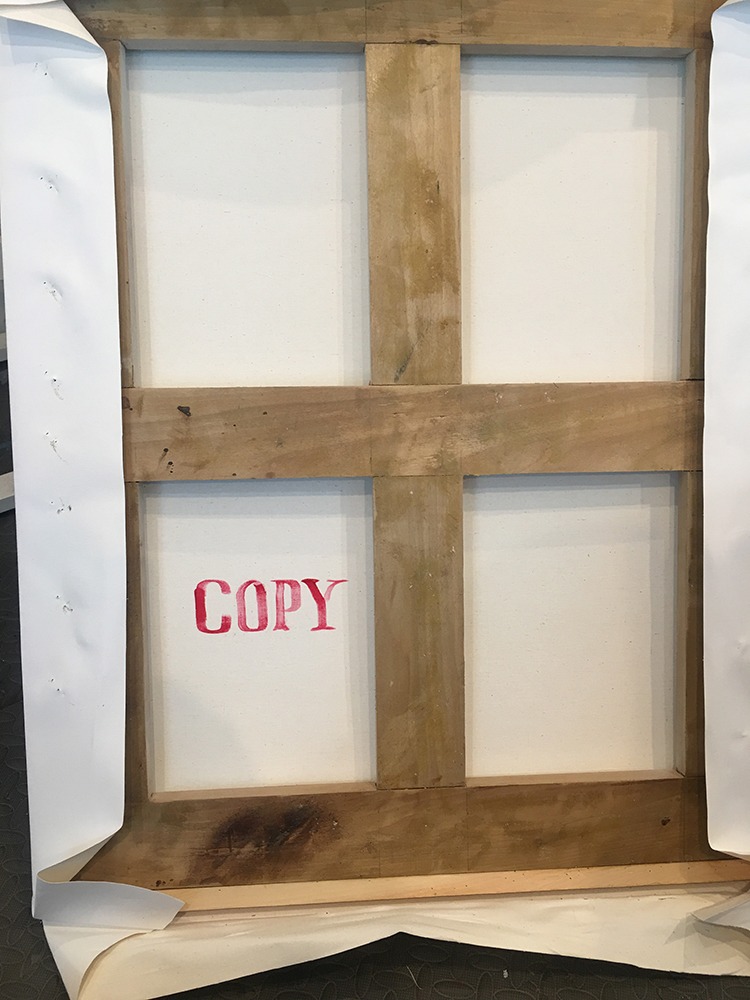 Photo of the back of a canvas that says "COPY".